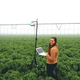 A Prospera scientist working with a camera mounted on a movable sprinkler system.
